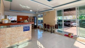 A hotel reception area with a reception desk, a clock, and a seating area with chairs. - Veerakit Grand Hotel Udon Thani (Udon Thani)