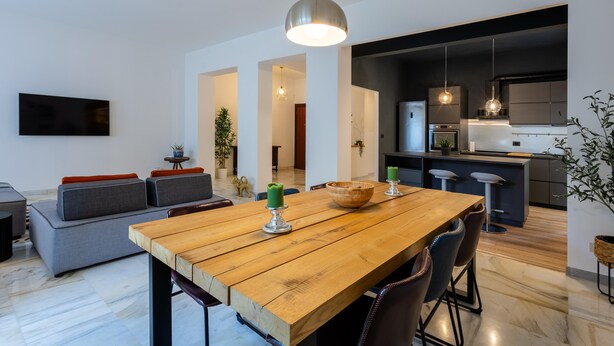 Una cucina moderna con mobili scuri, un'isola centrale e luci a sospensione.