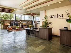 A spacious lobby with a reception desk, seating area, and large windows. - Waikiki Serenity – Modern Luxury & Views (Honolulu)