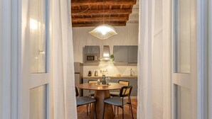 Een moderne keuken met een ronde eettafel, stoelen en een hanglamp.