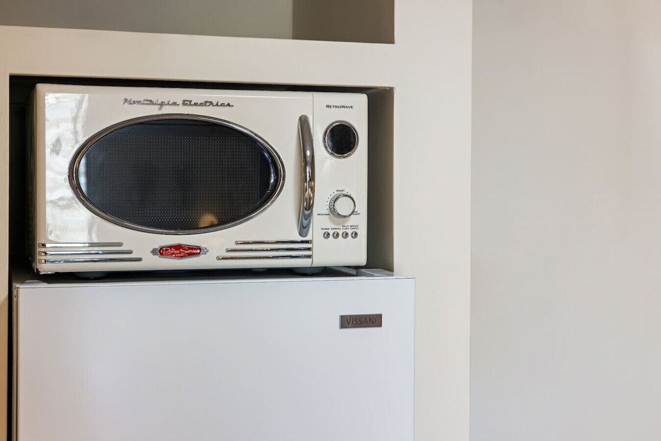 Eine im Retro-Stil gestaltete Mikrowelle mit Bedienfeld und einer Marke auf der Vorderseite.