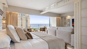 A modern bedroom with a large bed, a balcony with a view of the ocean, and a cityscape in the background. - Waikiki Wave Retreat: Ocean Luxe on 17F (Honolulu)