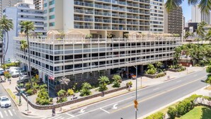 A multi-story hotel with a modern design, featuring balconies and a parking garage. - Heart of Waikiki • Steps to Beach • Cozy Studio (Honolulu)