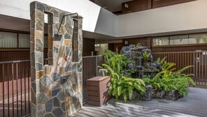 A stone archway, a water feature, and a wooden deck. - Urban Paradise with a Complimentary Parking (Honolulu)