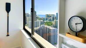 Ein Zimmer mit großem Fenster, einer Wanduhr und einem an der Wand liegenden Paddel.