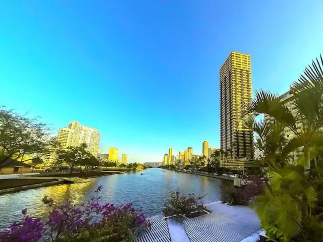 Un río con edificios a un lado y un puente a lo lejos.