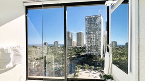 Un baño con un ventanal grande que ofrece vistas a edificios de gran altura y un paisaje urbano.
