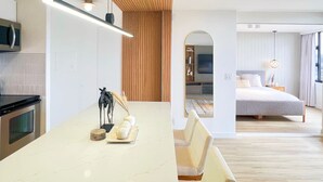 Eine moderne Küche mit Marmorarbeitsplatte, Holzboden und einem Essbereich mit einer Bank.