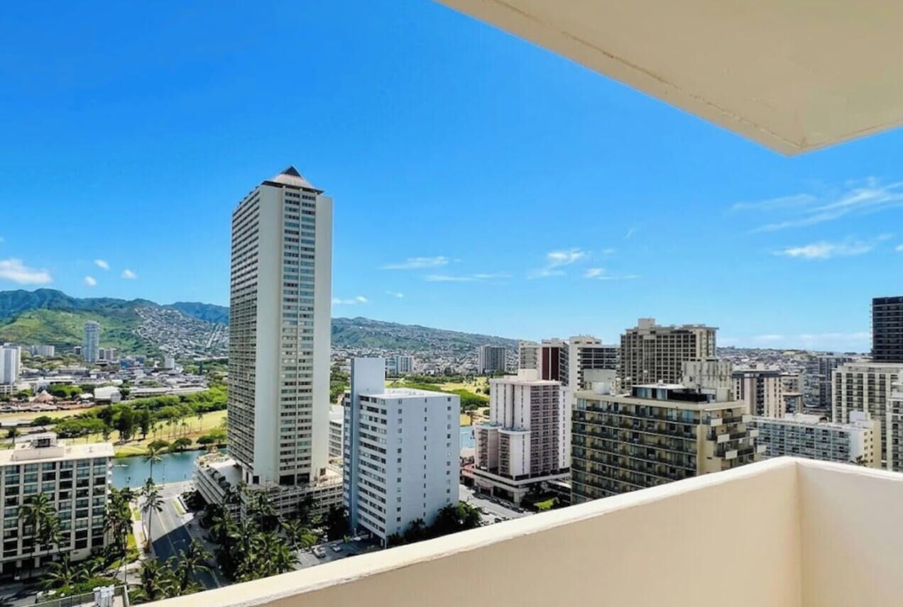 Ein Hochhaus mit Blick auf eine Skyline und Berge im Hintergrund.