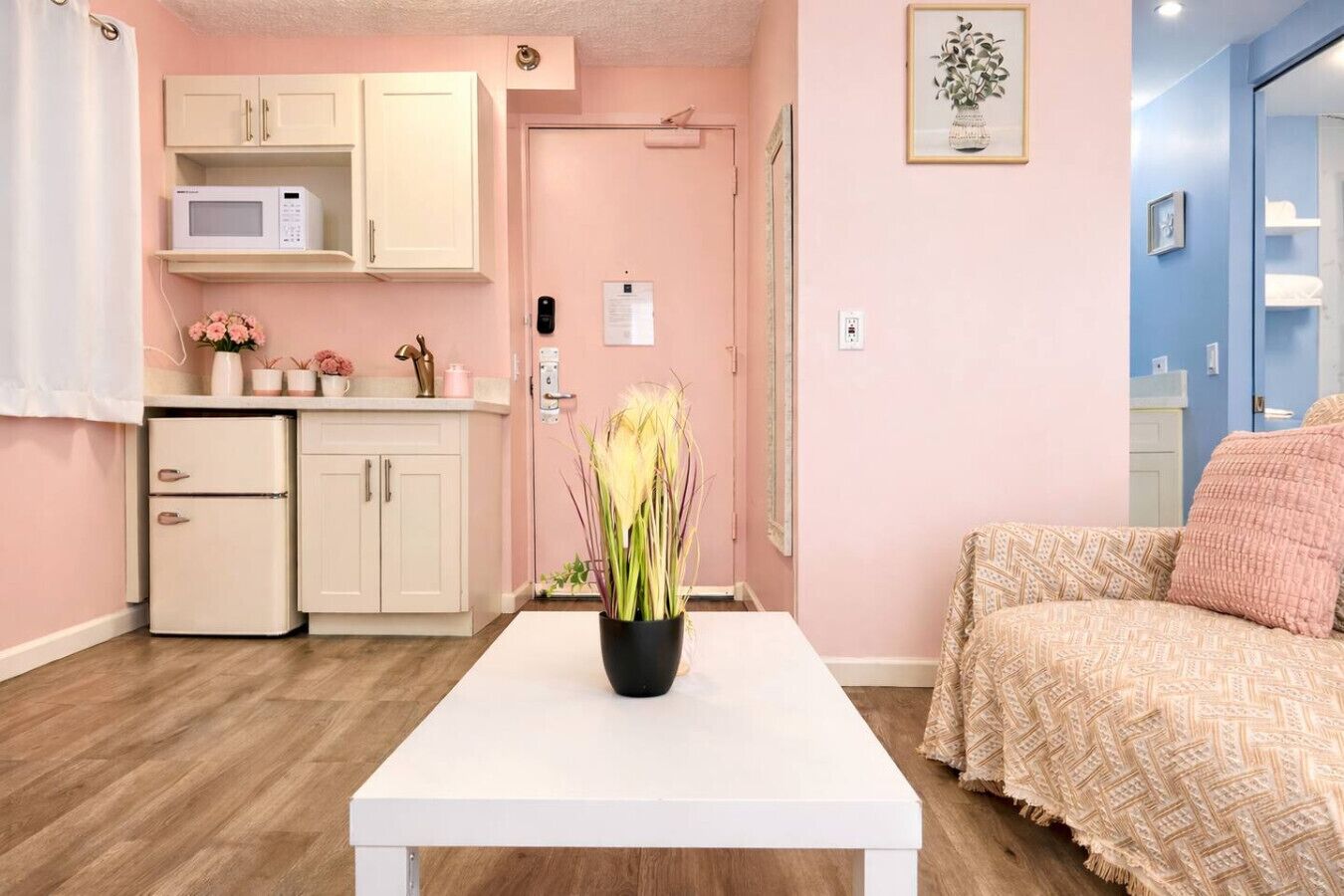 A compact living space with a kitchenette, a dining table, and a bed.