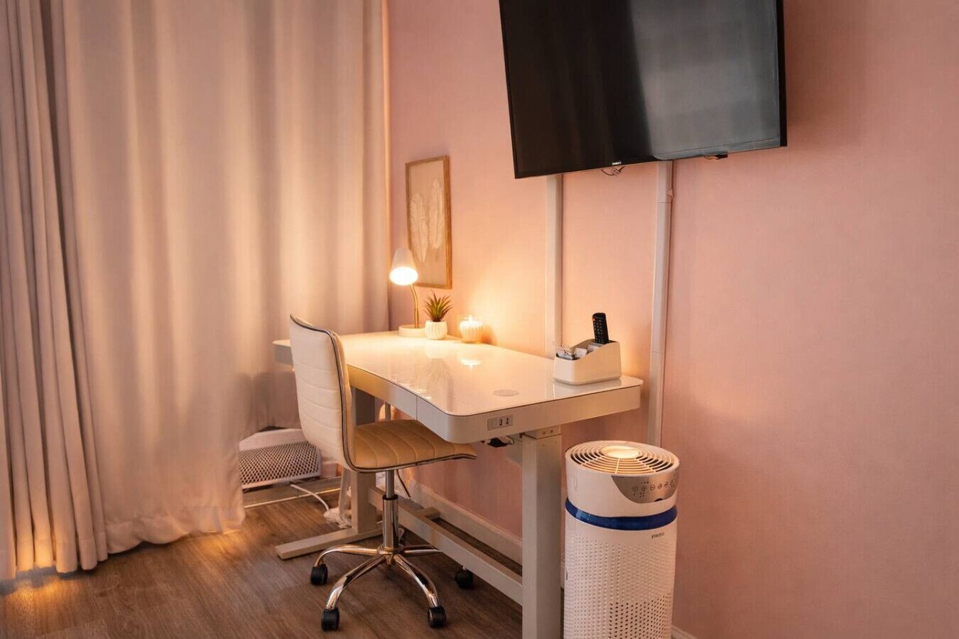 Ein Hotelzimmer mit Schreibtisch, Stuhl, Fernseher, Lampe und Mülleimer.