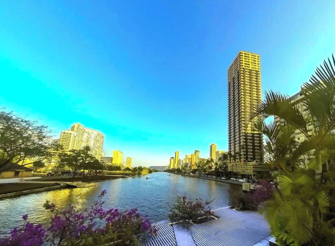 A river with buildings on one side and a tall skyscraper on the other.