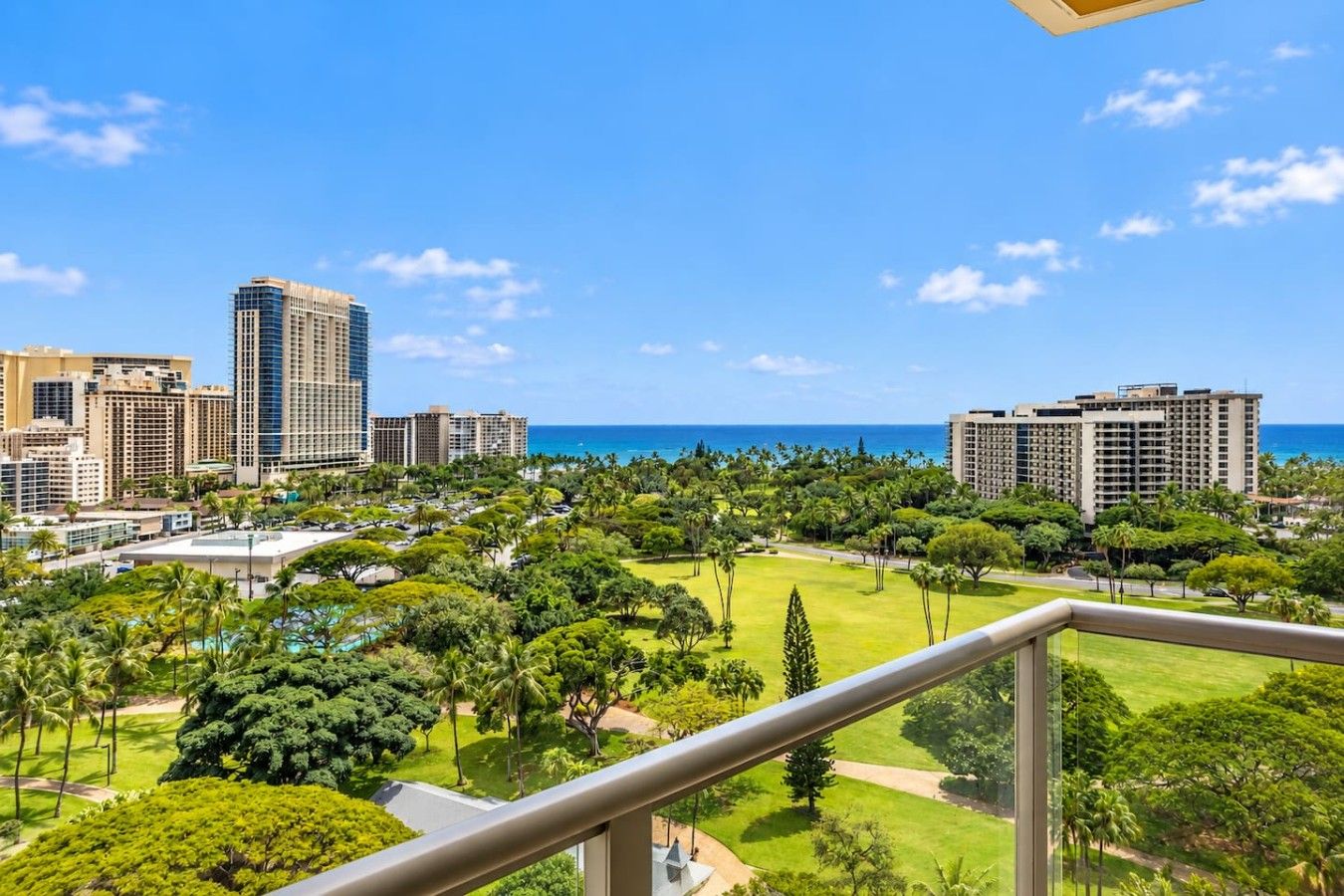 A high-rise hotel overlooking a coastal cityscape with a view of the ocean.