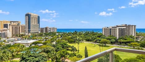 A high-rise hotel overlooking a coastal cityscape with a view of the ocean.