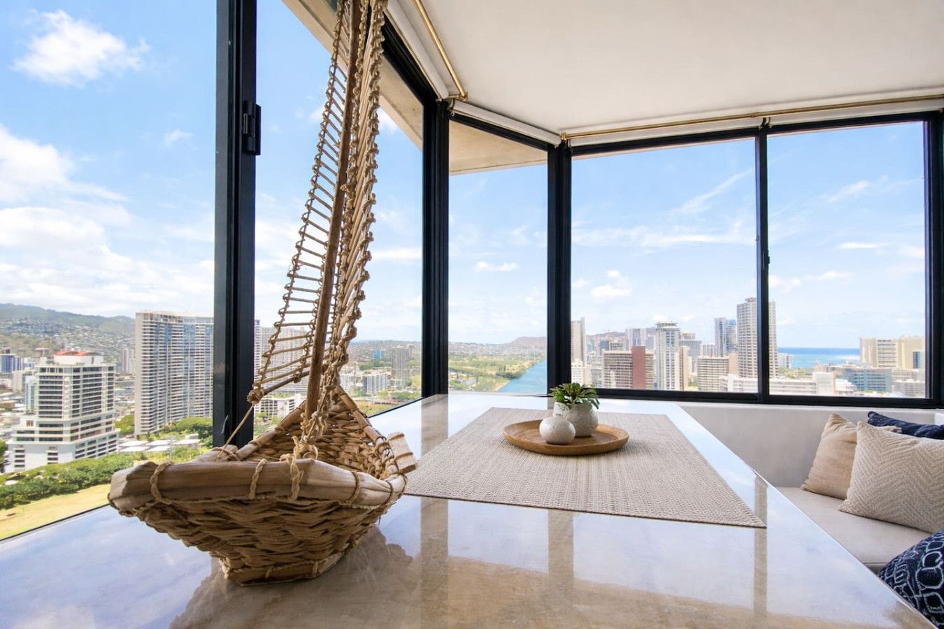 A modern room with a large window, a hanging hammock, and a view of a cityscape.