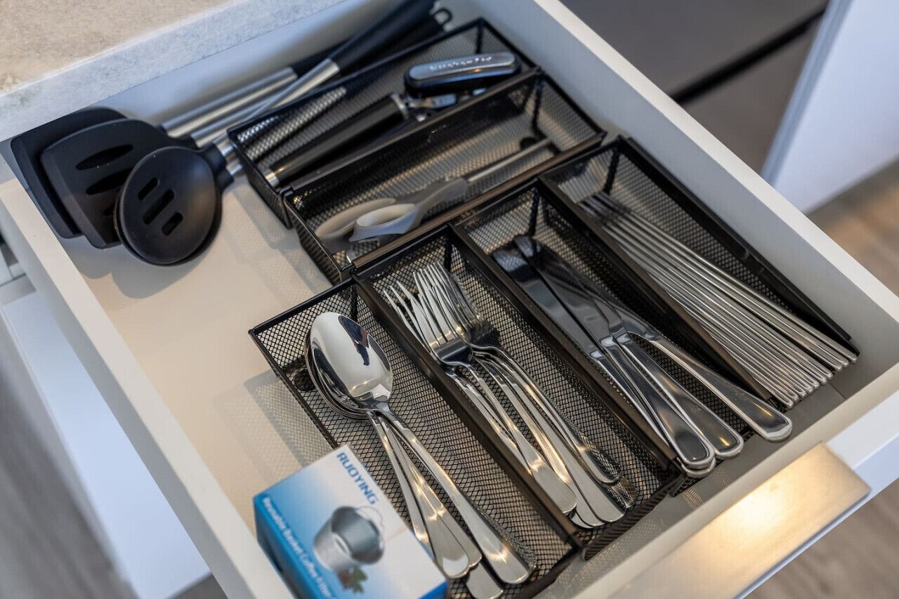 Un cajón con utensilios de cocina y una caja etiquetada 