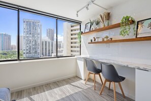 A modern kitchen with a large window, two chairs, and a white countertop. - Waikiki Oasis Haven: Your Coastal Escape (Honolulu)