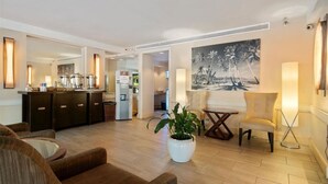 A modern hotel lobby with a seating area, a bar, and a large painting on the wall. - PW9F-23 Modern Cozy Waikiki Studio Across Hilton Village 9 (Honolulu)