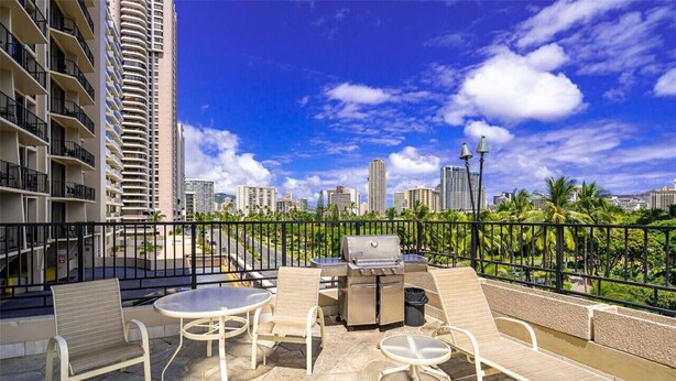 A rooftop patio with outdoor furniture, a grill, and a city skyline view. - PW9F-23 Modern Cozy Waikiki Studio Across Hilton Village 9 (Honolulu)