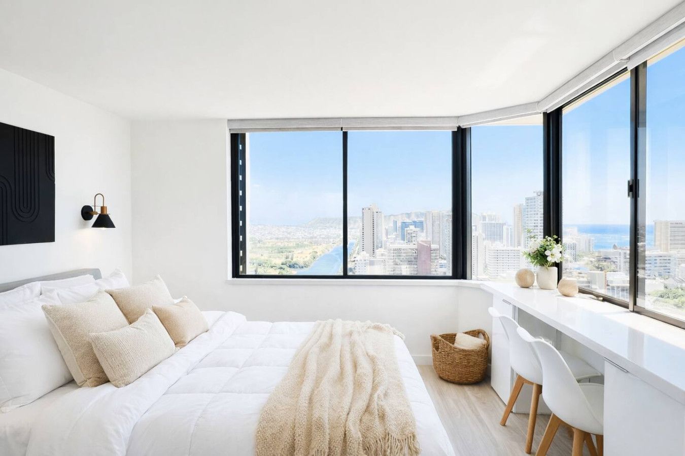 A modern bedroom with a city view, a bed with white bedding, a desk with a chair, and a large window.