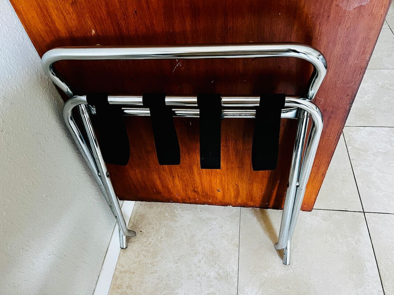A wooden desk with a chrome frame and a black object attached to it.