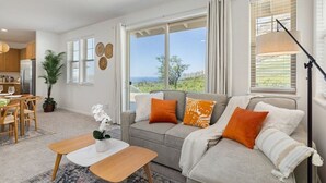 A spacious living room with a sofa, coffee table, and dining area. - Makaha Valley - Few Mins away to Beach (Waianae)