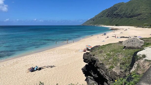 A beach with clear turquoise water, a sandy shore, and a large rock with 'KEAWA ULA BAY' inscribed. - Makaha Valley - Few Mins away to Beach (Waianae)