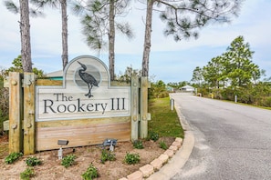 A wooden sign with a bird and the text 'The Rookery III' for a property. - 5002 Rookery 3 Sea La Vie (Gulf Shores)