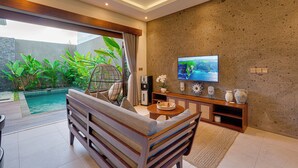 Un salon moderne avec une piscine, des sièges confortables et un téléviseur.