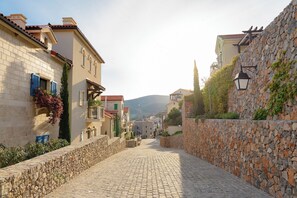 A cobblestone street flanked by buildings with stone walls and traditional architecture. - Luštica Bay 1-bedroom sea view apartment (Radovići)