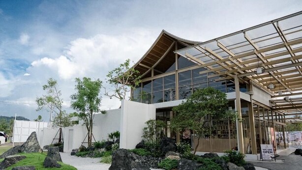 A modern building with a glass facade and a covered entrance area. - Kiyomizu Onsen &Glamping Resort Saraburi (Nong Khae)