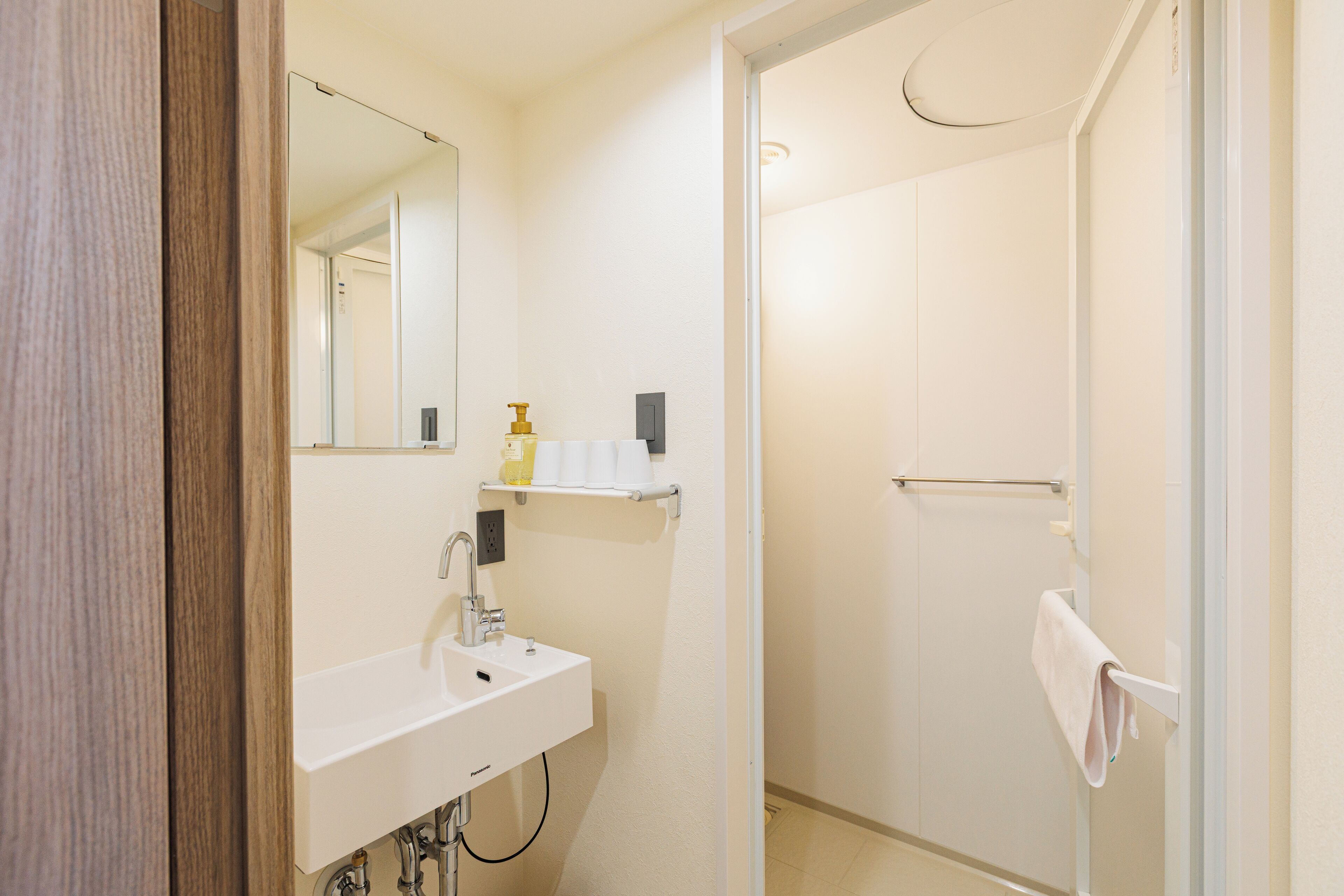 A bathroom with a white sink, mirror, and towel rack.