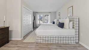 A bedroom with a large bed, a dresser, and a closet. - Charming 2BR/2BA Condo - Steps from Auburn Campus (Auburn)