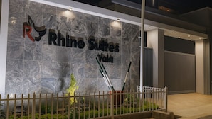 Una entrada moderna de edificio con un letrero que dice "Rhino Suites You".