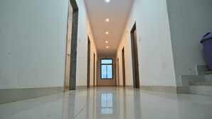 A long, narrow hallway with a polished floor and recessed lighting. - Hotel Raj Palace & Restaurant (Danta Ramgarh)