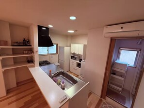 Comfort villa | Privékeuken | Een magnetron, een kookplaat, kookgerei, borden en bestek