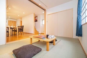 A traditional Japanese room with tatami flooring, a low table, and a sliding door. - Asakusa hanabi (Tokyo)
