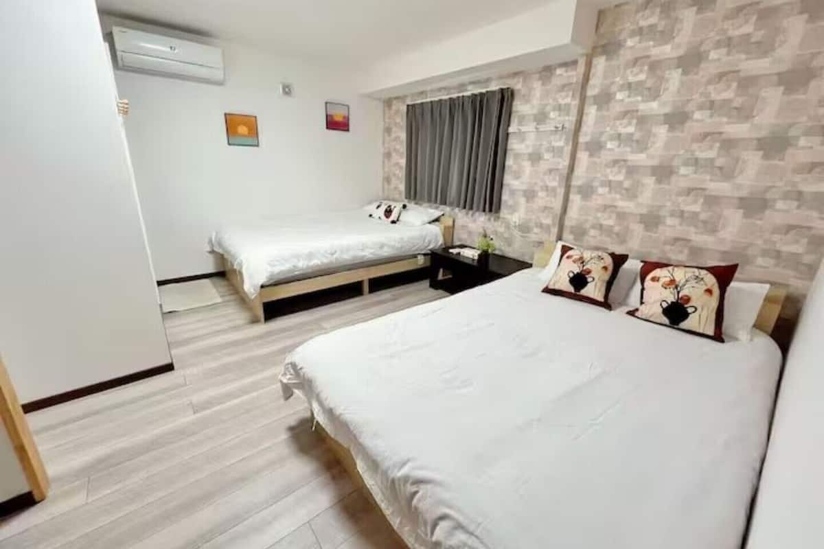 A bedroom with a bed, a desk, and a wardrobe.