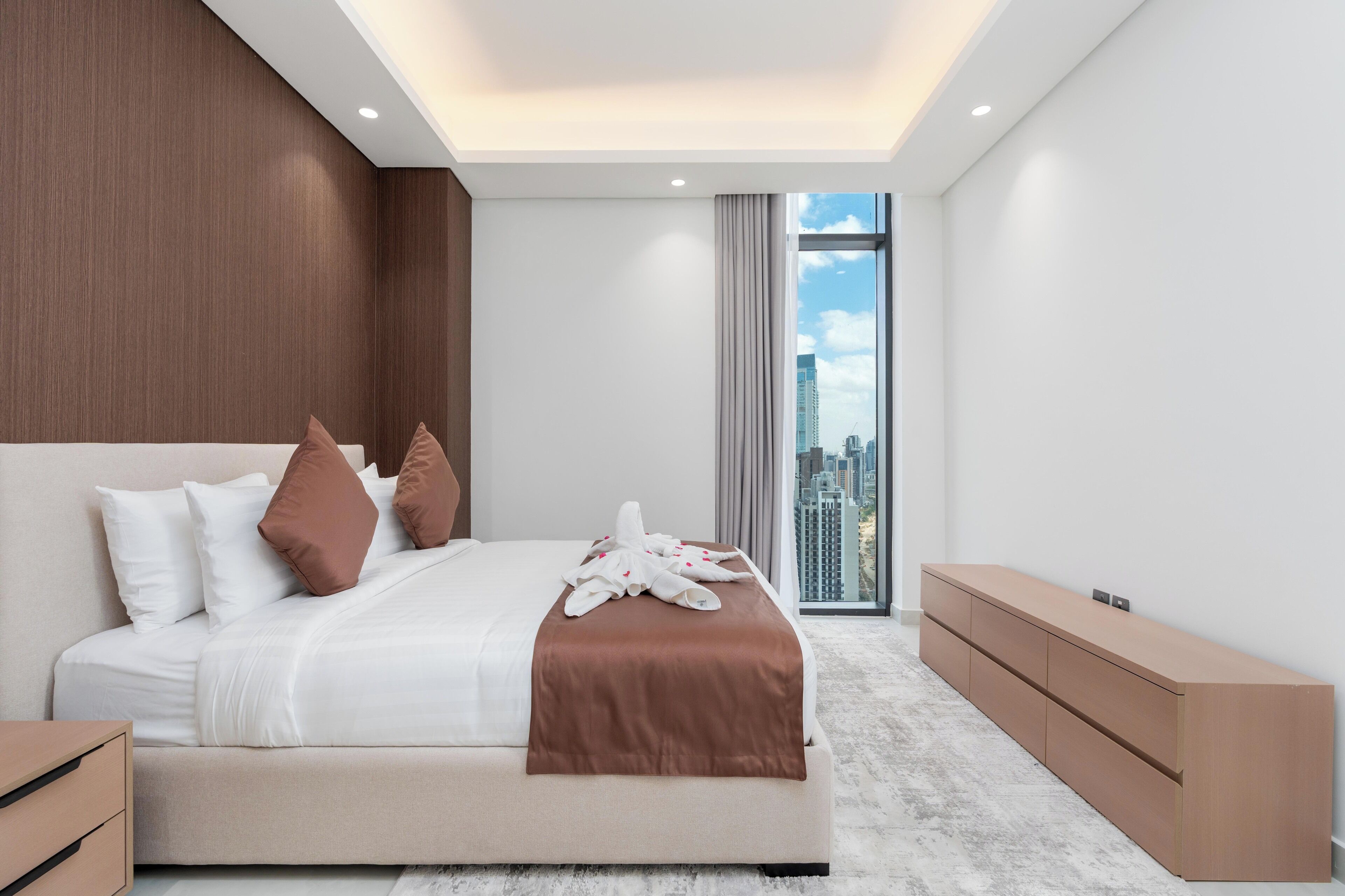 Una habitación de hotel moderna con una cama grande, vistas a la ciudad y un diseño minimalista.
