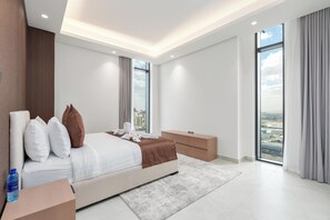 A modern hotel room with a large bed, a wooden headboard, a city view, and a large window. - Samaya Holiday Homes Cloud Suites (Dubai)