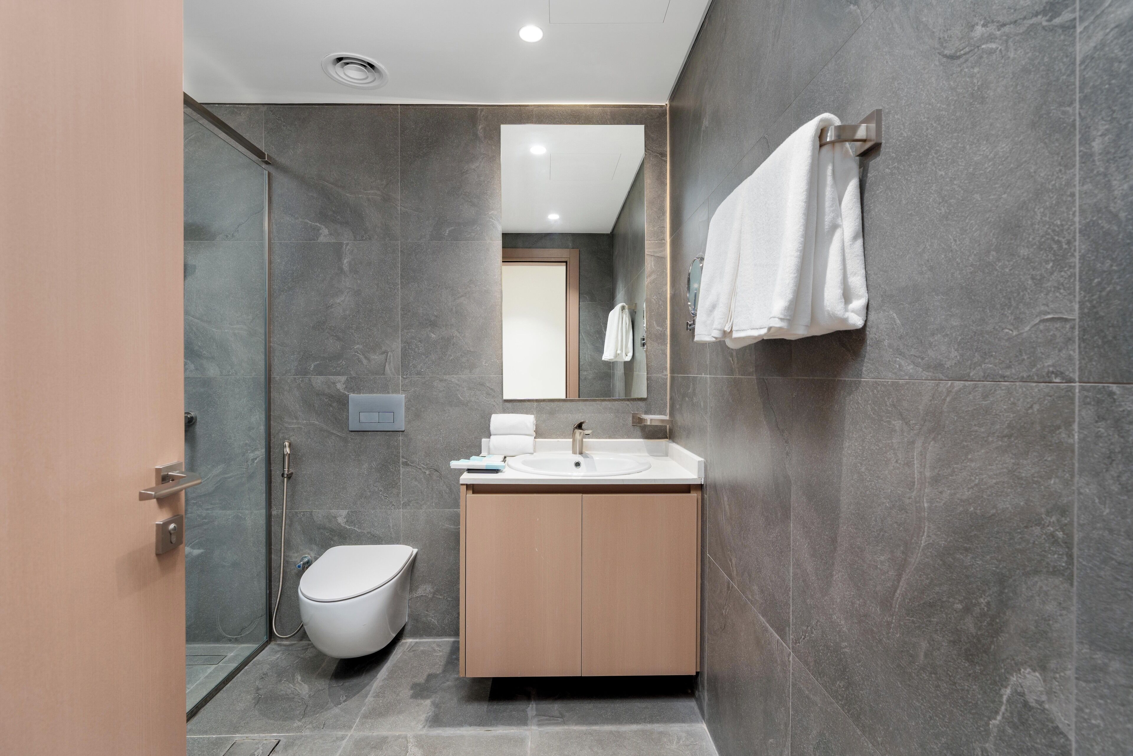 Une salle de bain moderne équipée d’une douche, de toilettes et d’un lavabo.