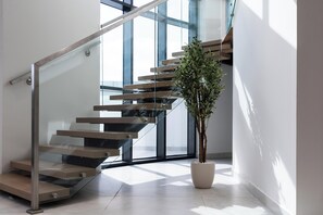 Eine moderne Treppe mit Glastrennwand und einem Blumentopf.