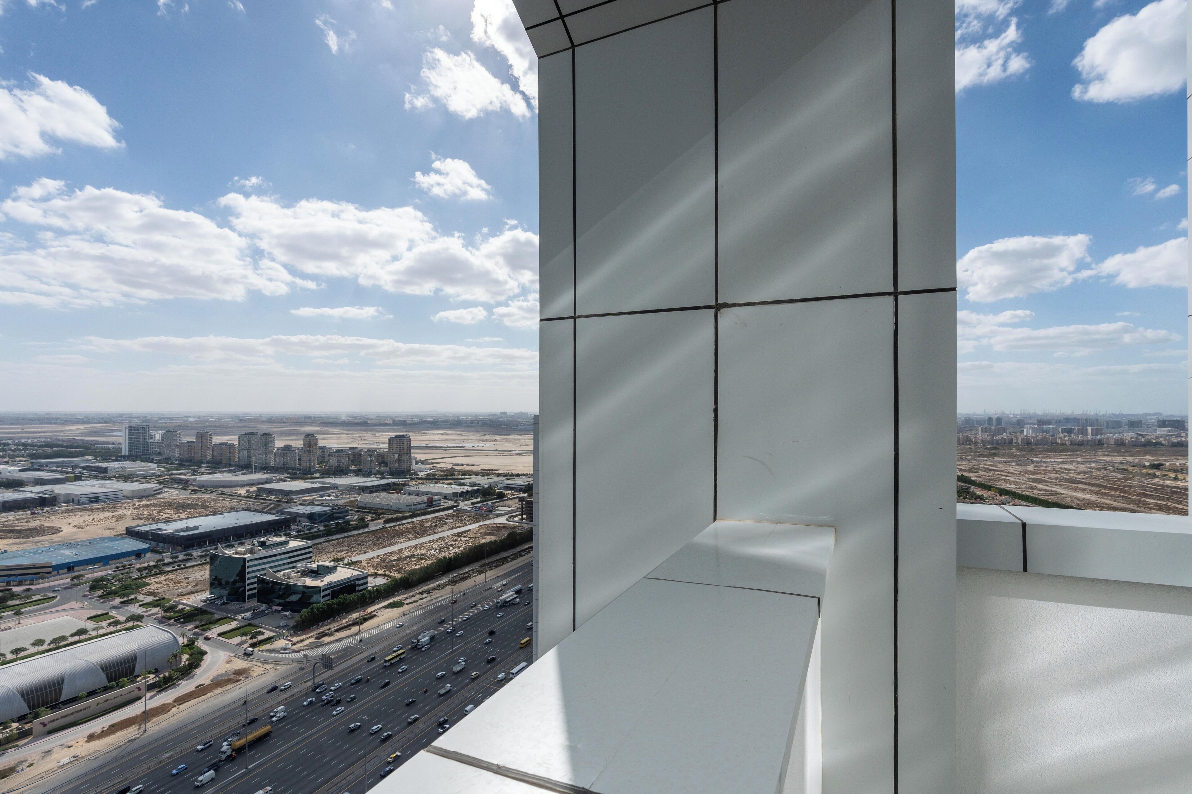 Un edificio de gran altura con vistas a un paisaje urbano, incluyendo calles y edificios.