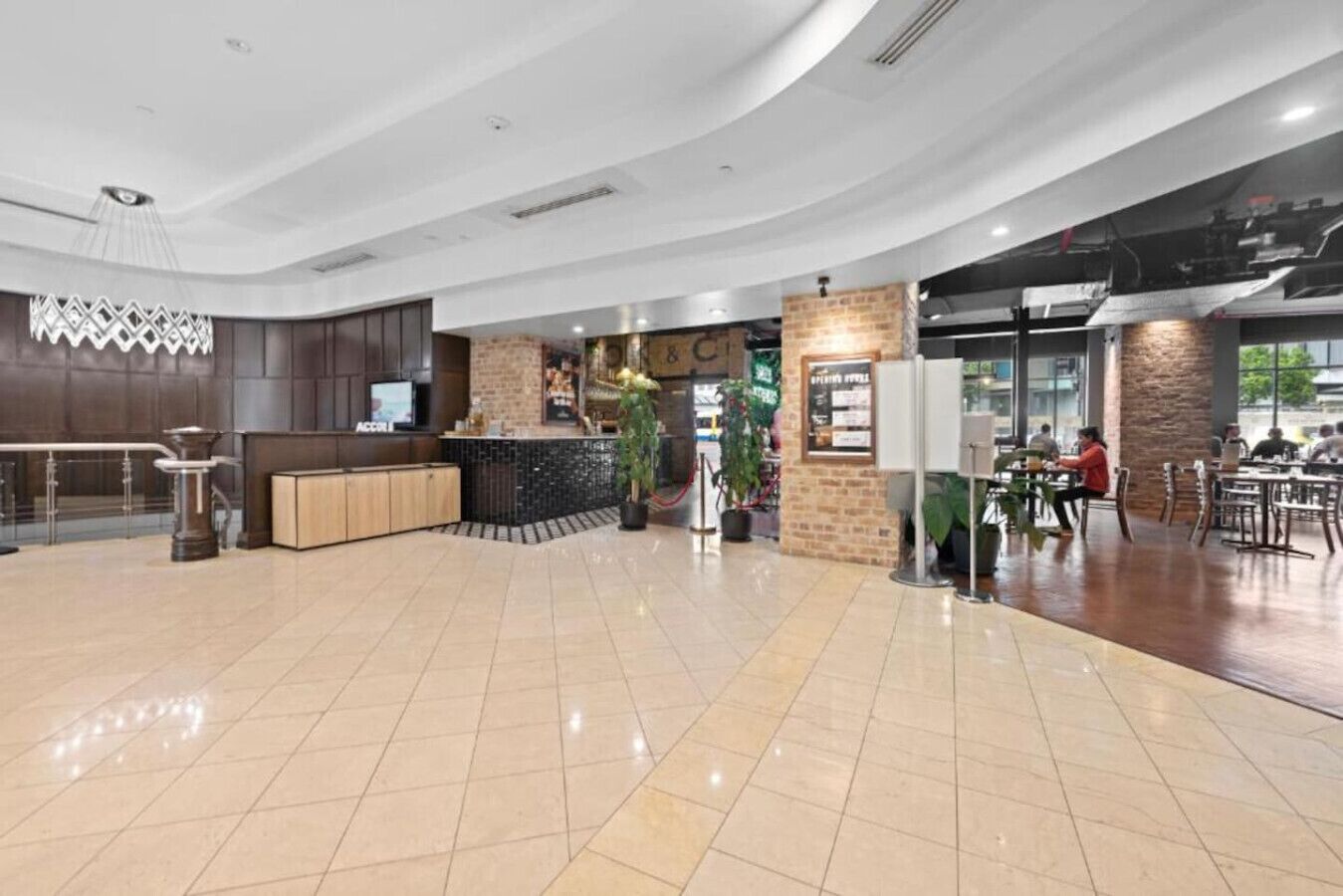 A spacious lobby with a reception desk, seating area, and a restaurant.