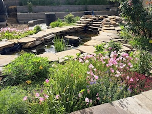 A garden with a pond, stepping stones, and various flowering plants. - Cottonwood Heights Escape/Minutes to Trails & Views (Cottonwood Height)