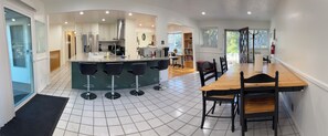 A modern kitchen with a central island, bar stools, and a dining table with chairs. - Cottonwood Heights Escape/Minutes to Trails & Views (Cottonwood Height)