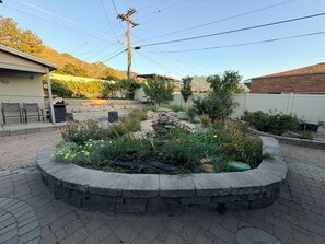 A landscaped garden with a stone border, a small pond, and various plants. - Cottonwood Heights Escape/Minutes to Trails & Views (Cottonwood Height)