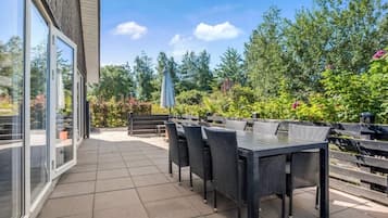 A patio with a table and chairs, a bench, and a grill area.