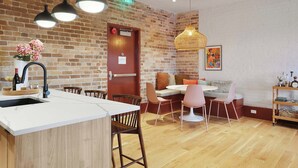 Una cucina moderna con parete in mattoni, pavimento in legno e isola centrale con lavello.