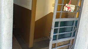 Een trap die leidt naar een kamer met een deur voorzien van een geëtste glazen ruit en een bordje met de tekst 'Welkom'.